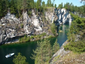 Лодка с туристами, плывущая по озеру мраморного карьера (Карелия)