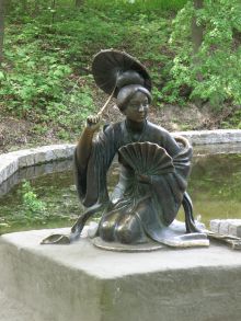 Бронзовая статуя китаянки возле китайского мостика